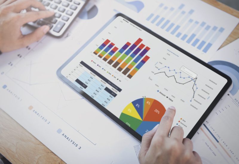 Businesswoman using a tablet to analysis graph company finance strategy statistics success concept and planning for future in office room.